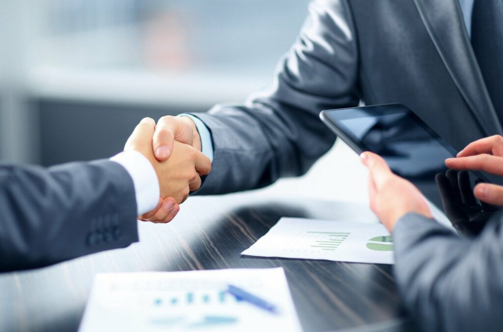 Two people shaking hands at the end of a deal