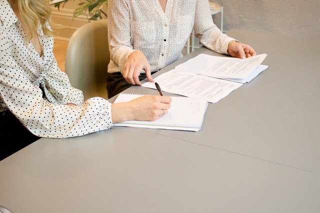 Two people signing loan documents